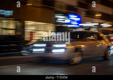 Immagine sfocata del veloce movimento Rolls-Royce Phantom salone su una strada di Londra di notte Foto Stock