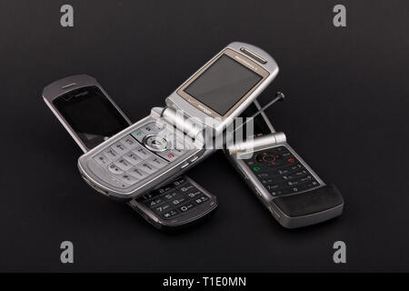 Tre flip cellulari su sfondo nero Foto Stock