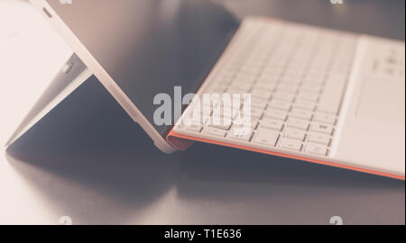 Close-up di bianco arancione notebook convertibile e la tastiera Foto Stock