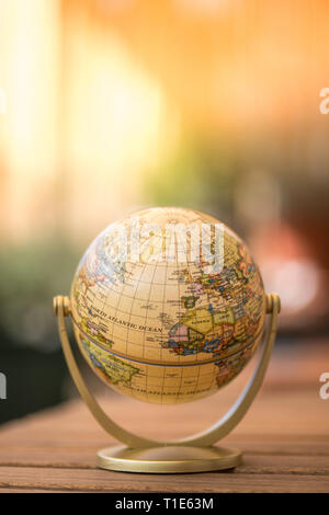 Pianificazione del viaggio successivo: globo in miniatura su un tavolo rustico Foto Stock