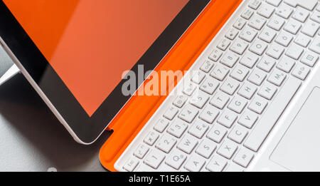 Close-up di bianco arancione notebook convertibile e la tastiera Foto Stock