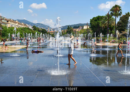 Nizza (sud-est della Francia): qualcuno camminando sul riflettente, piscina con getti di acqua e acqua di mister lungo la Promenade du Paillon per raffreddare duri Foto Stock