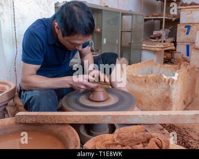 Potter nel suo workshop getta un vaso sul tornio del vasaio in Jianshui, Honghe prefettura, nella provincia dello Yunnan in Cina. Foto Stock