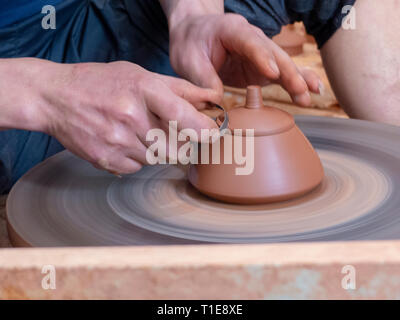 Potter nel suo workshop getta un vaso sul tornio del vasaio in Jianshui, Honghe prefettura, nella provincia dello Yunnan in Cina. Foto Stock