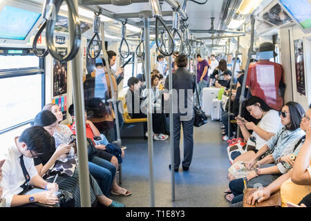 Passenegers utilizzando il proprio telefono cellulare dispositivi mentre il pendolarismo per città metropolitana a Bangkok, in Thailandia Foto Stock