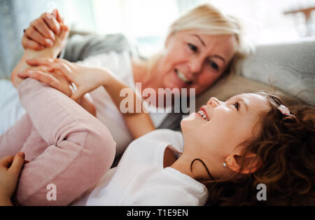 Un ritratto della bambina con la nonna avente il divertimento a casa. Foto Stock