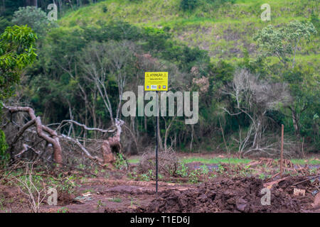 Brumadinho, Brasile. Xviii Mar, 2019. Un cartello con la scritta "Attenzione!" sorge nell'ambiente devastato nel Parque das Cachoeiras vicino a Brumadinho. Il 25 gennaio 2019, la diga del Córrego do Feijão miniera di ferro della società mineraria brasiliana Vale rotto e una frana di fango mortale avviato. Due mesi più tardi, ira, dolore e disperazione regola. (A dpa " Tutto è andato' - gli abitanti di Brumadinho soffrono di tragedia perineale') Credito: Rodney Costa/dpa/Alamy Live News Foto Stock