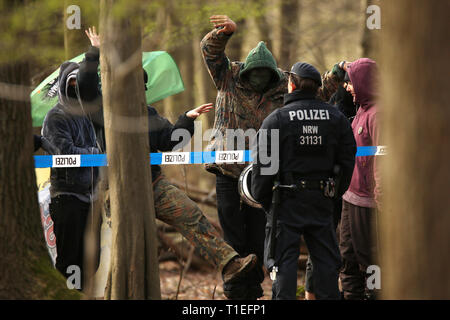 26 marzo 2019, della Renania settentrionale-Vestfalia, Düsseldorf: persone mascherate provate a provocare poliziotti a una barriera nella parte anteriore del case ad albero nella foresta di Hambach. La polizia vuole recuperare un sospetto di mortaio fecali da un albero di casa nella foresta di Hambach. La zona dove molti tree case si trovano è stato isolato, un portavoce della polizia ha detto martedì. La persona è sospettata di aver commesso un reato. Foto: David Giovani/dpa Foto Stock