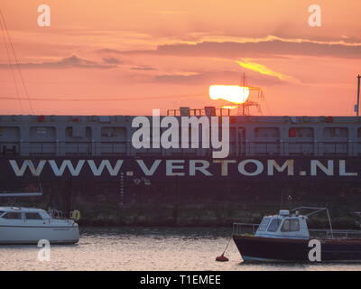 Queenborough, Kent, Regno Unito. 26 marzo, 2019. Regno Unito Meteo: questa sera al tramonto dorato in porto Queenborough Kent. Nella foto: general cargo nave 'FOKKO UKENA' passa attraverso gli stretti confini di Queenborough Harbour, prima di uscire in mare del Nord.Credit: James Bell/Alamy Live News Foto Stock