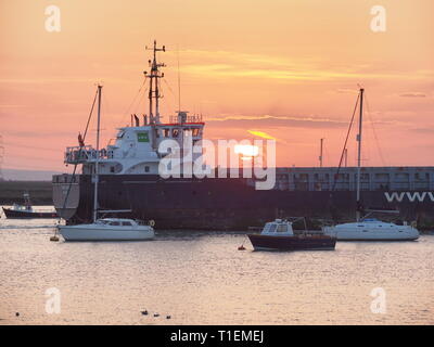 Queenborough, Kent, Regno Unito. 26 marzo, 2019. Regno Unito Meteo: questa sera al tramonto dorato in porto Queenborough Kent. Nella foto: general cargo nave 'FOKKO UKENA' passa attraverso gli stretti confini di Queenborough Harbour, prima di uscire in mare del Nord.Credit: James Bell/Alamy Live News Foto Stock