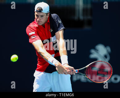 Giardini di Miami, Florida, Stati Uniti d'America. 26 Mar, 2019. John Isner, degli Stati Uniti, restituisce un colpo a Kyle Edmund, di Gran Bretagna, durante un quarto round della partita del 2019 Miami Open presentato da Itau professional tennis tournament, giocato all'Hardrock Stadium di Miami, Florida, Stati Uniti d'America. Isner ha vinto 7-6 (5), 7-6 (3). Mario Houben/CSM/Alamy Live News Foto Stock