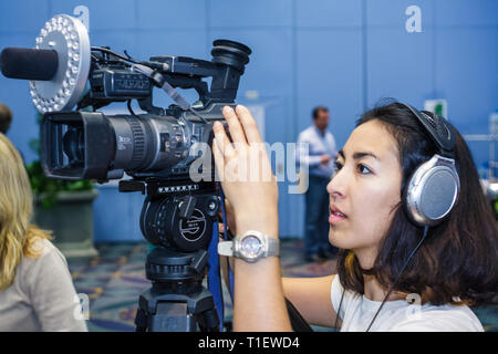 Miami Beach Florida,Miami Beach Convention Center,centro,donne asiatiche,video,macchina fotografica,digitale,microfono,videografo,lavoro,lavoro,dipendente w Foto Stock