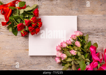 Il giorno di San Valentino o la festa della mamma biglietto di auguri e le rose su un tavolo di legno Foto Stock