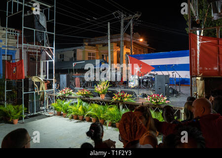 Santa Clara, Cuba - gennaio 27 2019: Stage con apparecchiature audio decorata con fiori e una bandiera cubana in background. Persone in attesa per la perfo Foto Stock