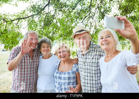 Gruppo di anziani come amici prendere un selfie con lo smartphone in natura Foto Stock