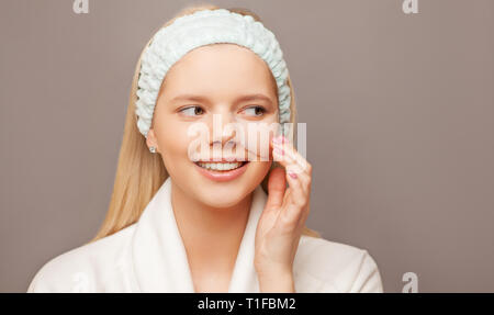 Giovane donna con fresco e salutare la pelle e i peli utilizzando patch e sorridente. La cosmetologia, bellezza e spa. Foto Stock