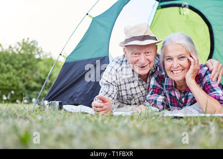 Felice coppia senior si rilassa mentre il Campeggio in tenda mentre camping in natura Foto Stock