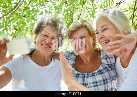 Tre allegro senior donne prendere un selfie con il proprio smartphone Foto Stock
