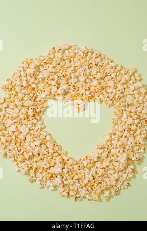 Il Popcorn mockup su sfondo pastello top copia vista spazio. Forma di cuore Foto Stock