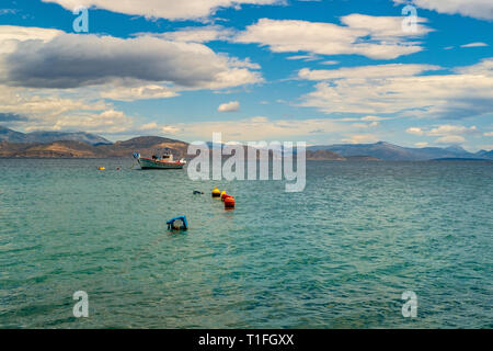 In legno barca da pesca galleggianti in una bella chiara acqua color smeraldo. Peloponneso, Grecia. Foto Stock