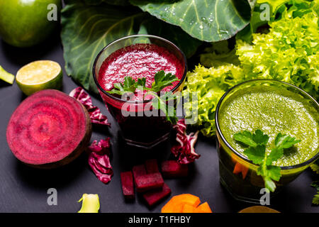 Bibita salutare con frutta e verdura in nero lo sfondo di legno. Foto Stock