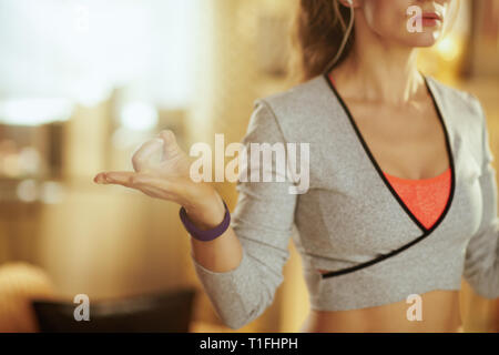 Primo piano sul rilassante mani di donna attiva fare yoga a casa moderna. Foto Stock