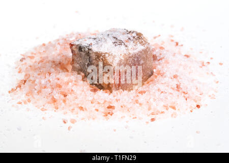 Halite naturale minerale nella pila di granito rosa Sale Himalayano su sfondo bianco Foto Stock