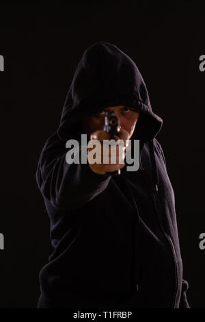 Man in Black hoodie punti pistola Foto Stock