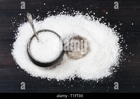 Vista superiore del vintage sale di argento in cantina con cucchiaio, ruvida Halite naturale minerale e grani di sale di roccia su legno marrone scuro board Foto Stock