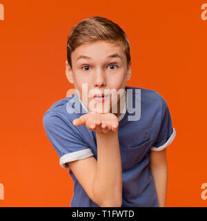 Bel ragazzo caucasico invio blow kiss con pout labbra Foto Stock