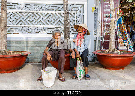 MY THO, VIETNAM - Febbraio 24, 2018: vecchia donna vietnamita a sedersi su una panchina di My Tho, Vietnam Foto Stock