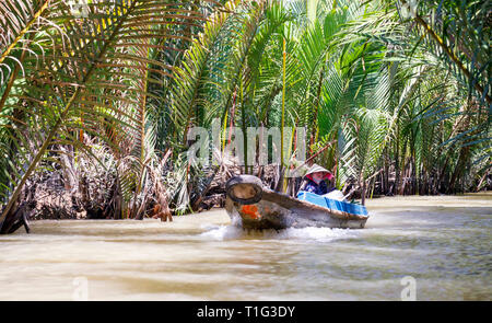 MY THO, VIETNAM - 24 febbraio 2018: il vietnamita con barche a lungo attesa per turisti per dare loro un giro sulle rive del Mekong, Vietnam Foto Stock