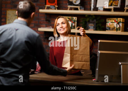 Immagine di donna venditore con sacchetto e l uomo dal di dietro Foto Stock