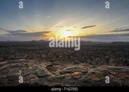 Africa - Kenya - Samburu National Park. Le pianure tramonto Cielo drammatico, rocky in primo piano Foto Stock