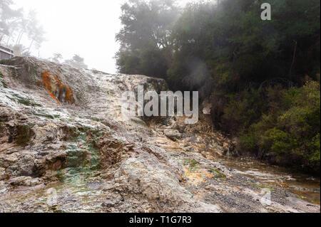 Paesaggio di cottura a vapore, Bridal Veil Falls al Wai-O-Tapu geotermica parco vulcanico, Rotorua, Nuova Zelanda. Cascata di origine vulcanica di minerale di roccia colorata Foto Stock