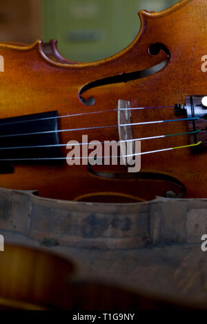 Di recente violino fatte sul display con la carcassa di un strumento danneggiato a Andrew Hutchinson il workshop presso Hoylake Wirral, nord ovest Inghilterra. Signor Hutchinson addestrato a Newark Scuola di Liuteria e stabilito il violino Shop nel 1982, dove il suo riparato, realizzato e ripristinato violini. Foto Stock