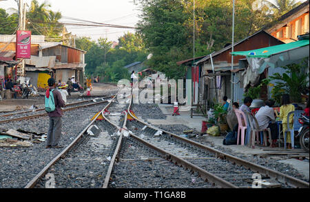 Le persone che vivono accanto a una linea ferroviaria. La vita di famiglia si passa accanto a una lettiera disseminata ferrovia via nei pressi di Battambang, Cambogia, stazione ferroviaria. Dic 2018 Foto Stock