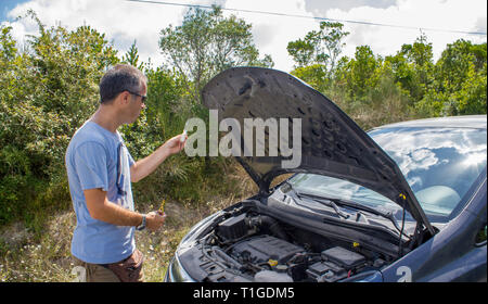 Guasto Auto sulla campagna. Ripartizione per auto. Uomo con ripartizione per auto. L'uomo controllando il motore dell'auto Foto Stock