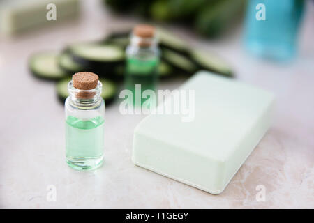 Estratto di cetriolo in piccola bottiglia con barra di sapone e fette di cetriolo. Foto Stock