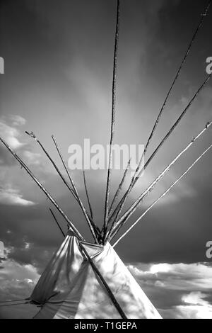 Ritagliate una vista ravvicinata in bianco e nero della parte superiore di un tende Tepee con drammatica sky in pianure occidentali al tramonto negli Stati Uniti Foto Stock