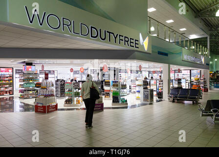 World Duty Free shop - un viaggiatore in World Duty free shop, partenze, Londra aeroporto di Southend, Southend Essex REGNO UNITO Foto Stock