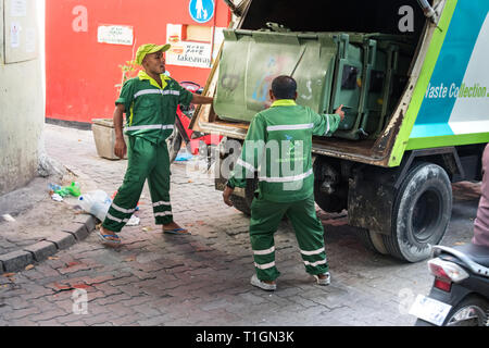 Maschio, Maldive - Febbraio 11th, 2019: due garbage collector caricamento di un cestino della spazzatura su un carrello in maschio, Maldive. Foto Stock