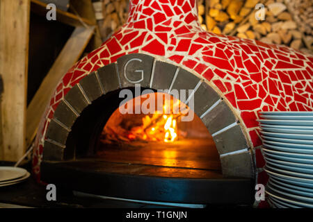 Un tradizionale a legna per pizza italiana forno con mosaico rosso in una pizzeria/trattoria/ristorante Foto Stock