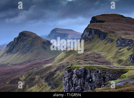 Uomo in piedi sul bordo del Quiraing all'alba, Trotternish Peninsula, Isola di Skye, Ebridi Interne, Scotland, Regno Unito. Modello rilasciato Foto Stock