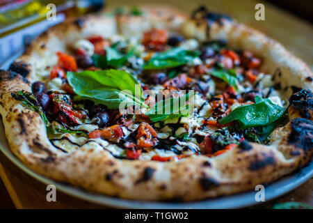 Italiano autentico stile napoletano pizza al forno a legna sul tavolo in una pizzeria ristorante trattoria Foto Stock