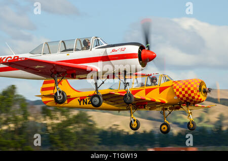 Due Yakovlev Yak-52 gli aerei che decollano a Wings Over Wairarapa airshow cappa al aérodrome, Masterton, Nuova Zelanda. ZK-KGB e ZK-YNZ piano Foto Stock