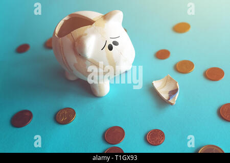 Monete in euro incollato rotto piggy coin bank, risparmi di denaro in home Budget e finanze concetto Foto Stock