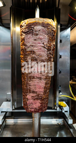 Coltello di döner tradizionale turca Döner Kebab carne. shawarma o giroscopi. Turco e greco o medio orientale in stile arabo Döner Kebab cibo spit nella parte anteriore del GRI Foto Stock