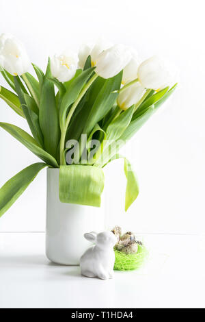 Pasqua. White tulipani in vaso, bunny, uova su bianco. Spazio per il testo Foto Stock