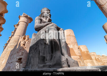 La gigantesca statua di Ramesse II nel Tempio di Luxor, Egitto, un antico e grande tempio egizio complesso situato sulla riva est del fiume Nilo in città Foto Stock